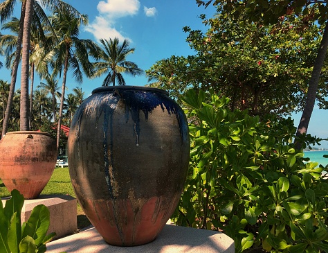 Handmade old ceramic amphora clay ceramic jars  in a garden, traditional clay craft container. Garden decoration concept.