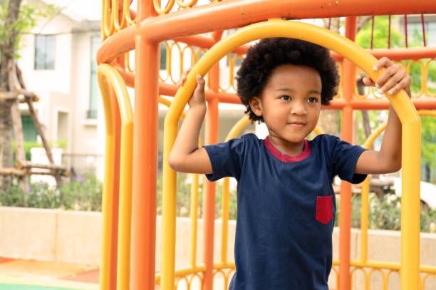 istock Cute African American boy having fun while playing on the playground on sunny day. Five years old. Outdoor activity. 1439925736