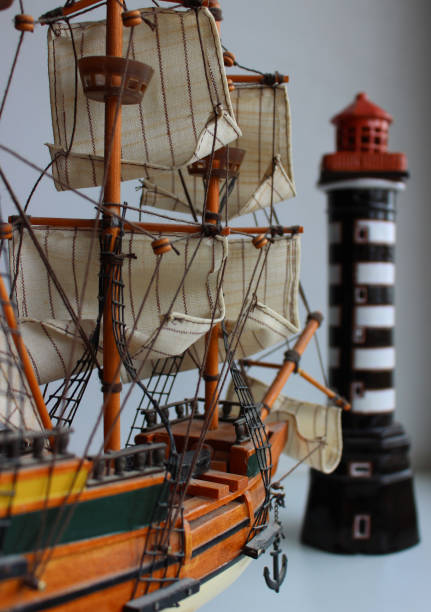 istock Back Angle View Of Scale Model Of Sailing Ship Toward The Toy Lighthouse Tower 1439927356