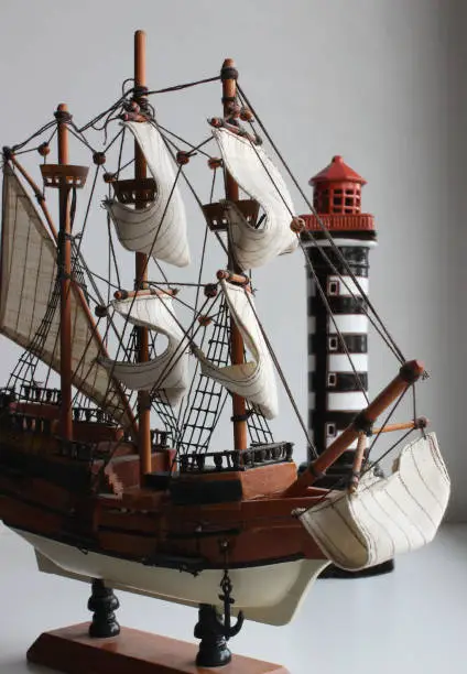 Scale Model Of Wood Sail Ship On A Model Stand With Beacon Tower Isolated Stock Photo