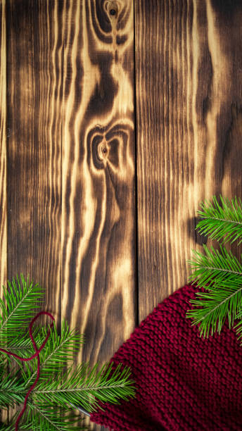 istock Started knitting on knitting needles, with yarn on a rustic wooden table, with green branches of a Christmas tree. Vertical forms for stories. 16:9 1439929011