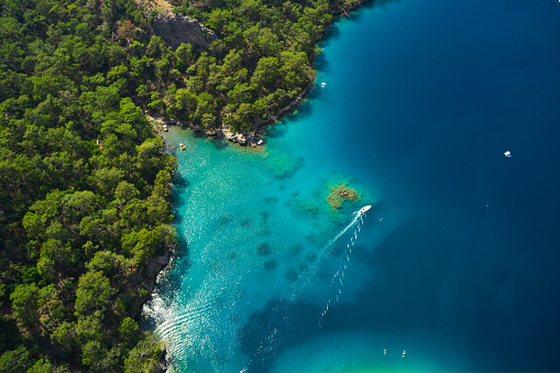 Aerial view of blue sea and boat sailing along the mediterranean coast. Landscape of turkish riviera nature