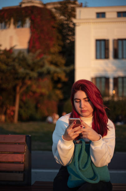 istock Young woman looking at messages on her phone. 1439930276