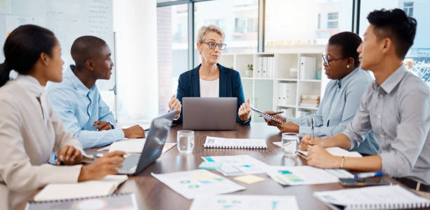 istock Manager meeting, employee planning and finance discussion with documents in office, conversation with team and partnership at work. Business boss talking to workers about strategy and collaboration 1439931466