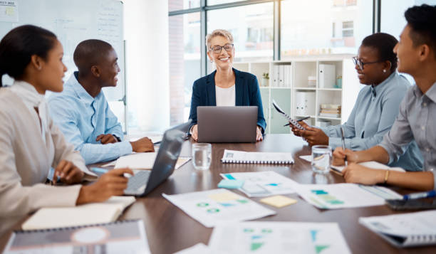 istock Meeting, teamwork and finance with a team planning and working on a strategy for growth and development in the boardroom. Collaboration, paperwork and training with a female leader, manager or CEO 1439931474