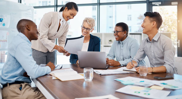 istock Diversity, business people and collaboration meeting at the office in document planning, analysis and teamwork strategy. Group of happy employee workers in a team discussion, project and paperwork 1439931940