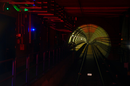 A train tunnel with crimson lighting