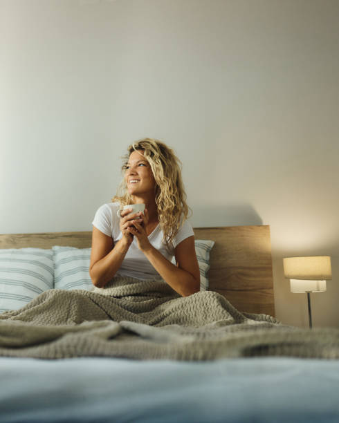 istock Happy woman day dreaming during coffee time in bed. 1439933679