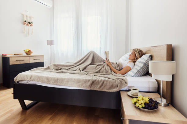 istock Relaxed woman reading a book in a bed. 1439933790