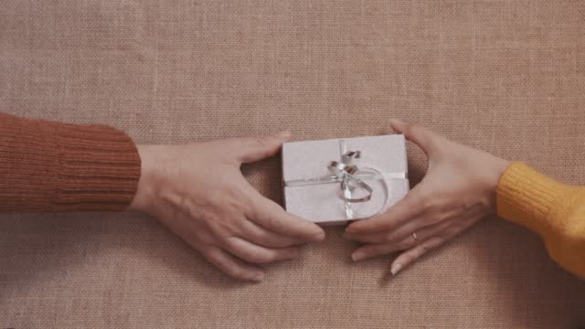 Top view of a woman and a man exchanging gifts. couple giving gifts to each other