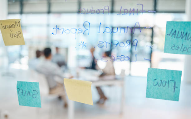istock Business meeting and schedule planning with sticky notes on workflow moodboard for corporate sales company success. Creative post it notes of teamwork brainstorming and project strategy on glass wall 1439935678