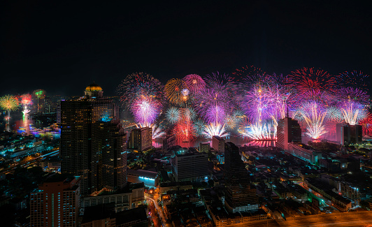 Celebrating fireworks in New Year with skyscrapers building along the Chao Phraya River in Bangkok, Thailand