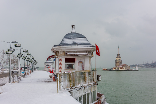 Snowy day in Uskudar. View of Maiden's Tower with seagulls in Uskudar, Istanbul, Turkey.