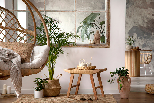 Creative composition of living room interior with hanging swing, stool, plants in flowerpot, window, commode and personal accessories. Home decor. Template.