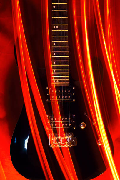Black electric guitar and abstraction in the form of light strips