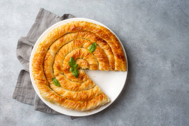 istock Traditional Turkish pastry with spinach. (Turkish Name: Ispanakli Kol Boregi, Bosnak boregi). Handmade pastry with spinach filling. 1439940629