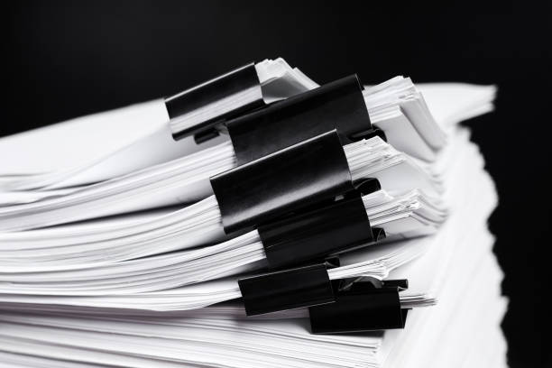 istock A stack of office papers, some of which are fastened with black binders 1439944072