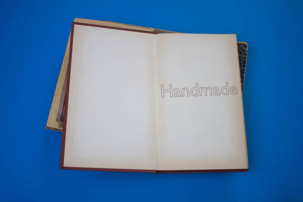 istock Handmade word in opened book with vintage, natural patterns old antique paper design. 1439944663