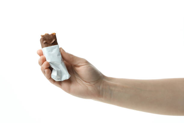 istock Female hand holds candy bar, isolated on white background 1439945747