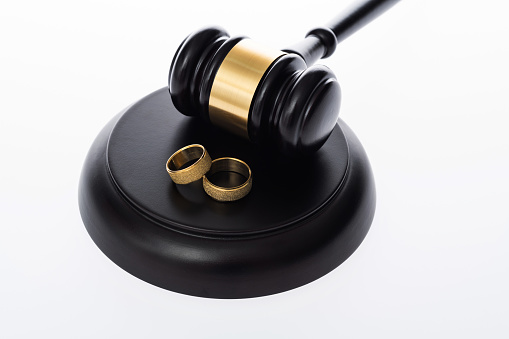 Wedding rings and gavel on white background.