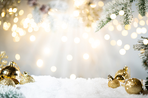 Christmas fir tree background with baubles, snowflake and glowing Christmas lights bokeh