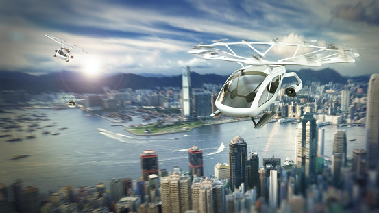 Conceptual eVTOL (electric vertical take-off and landing) aircrafts flying over a modern city.