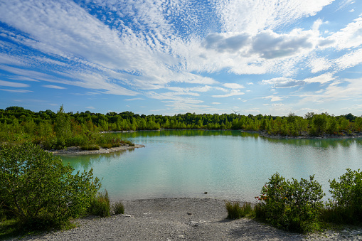 View of the Dyckerhoff lake in Beckum. Quarry west. Blue Lagoon. Landscape with a turquoise blue lake and the surrounding nature.