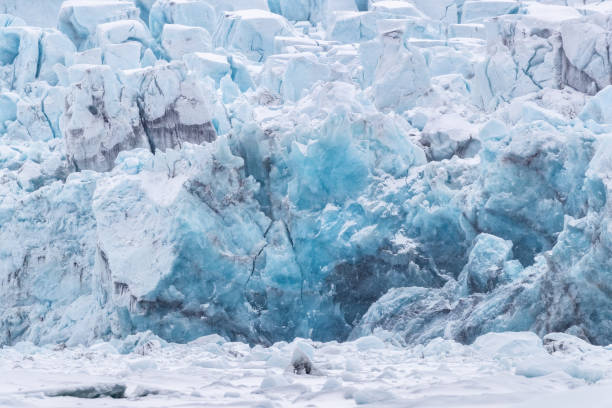 Front edge of a glacier in Svalbard, a Norwegian archipelago between mainland Norway and the North Pole, showing a crack in the ice as it is about to calve.