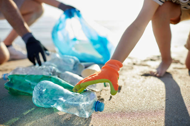 ragazzo e padre che indossano i guanti che raccolgono le bottiglie - save the planet foto e immagini stock