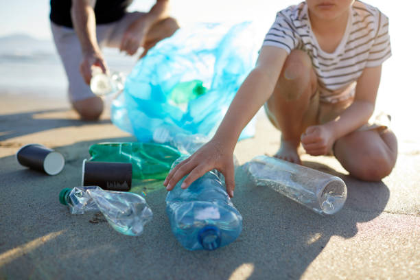istock Boy picking up abandoned water bottles with father 1439954061