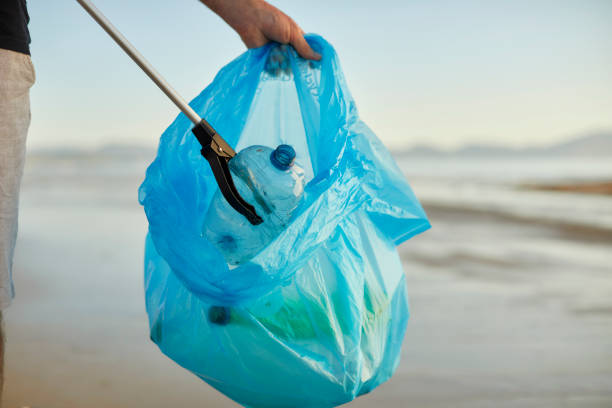istock Environmentalist collecting water bottle with litter picker 1439954101