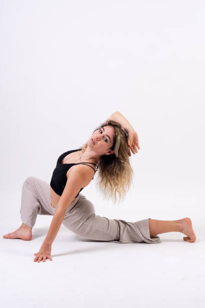 istock Young dancer in studio photo session with a white background, ballet, stretching and looking 1439954338