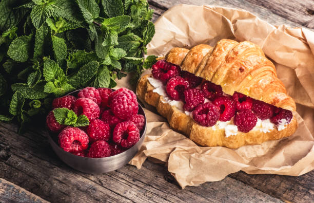 Delicious crispy croissant with fresh raspberries and ricotta stock photo