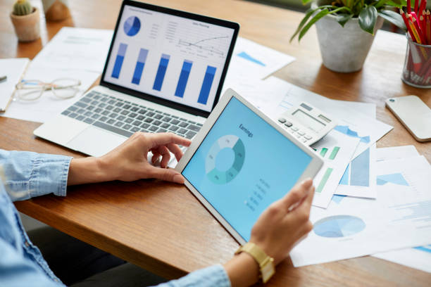 istock Businesswoman comparing financial diagrams on tablet PC 1439957302