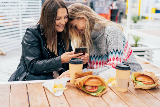 istock Two women are laughing at jokes on social networks using a mobile phone to view. 1439957543