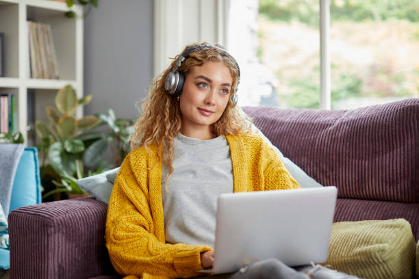 istock Woman with laptop day dreaming at home 1439957664