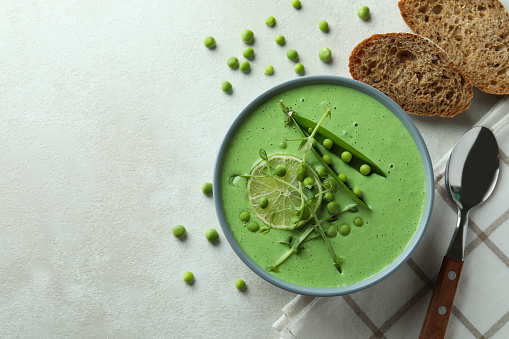 Concept of tasty eating with pea soup on white textured table