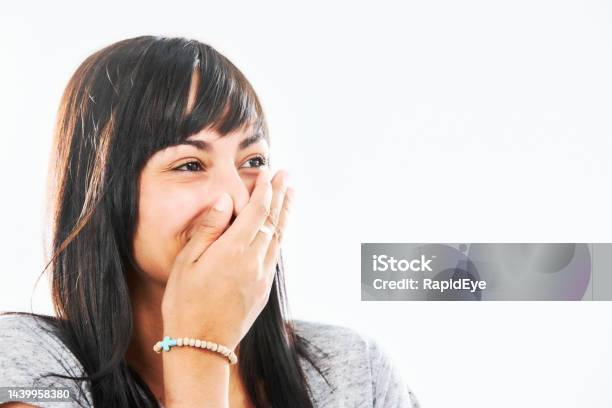 Scandalous Beautiful Young Woman With Long Dark Hair Covers Her Mouth As She Laughs Stock Photo - Download Image Now