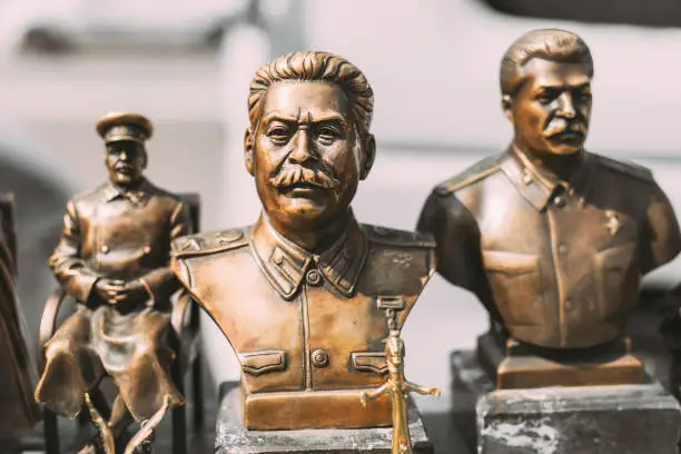 Photo of Soviet Leader Josef Stalin. Concept Of Nostalgia For Soviet Union. Miniature Bronze Figurines Of Joseph Stalin