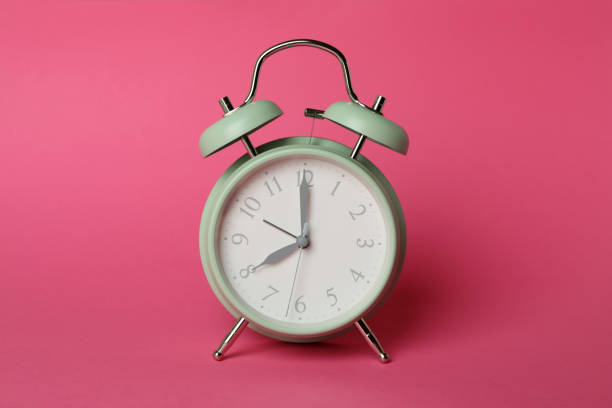 istock Stylish mint alarm clock on pink background 1439960112