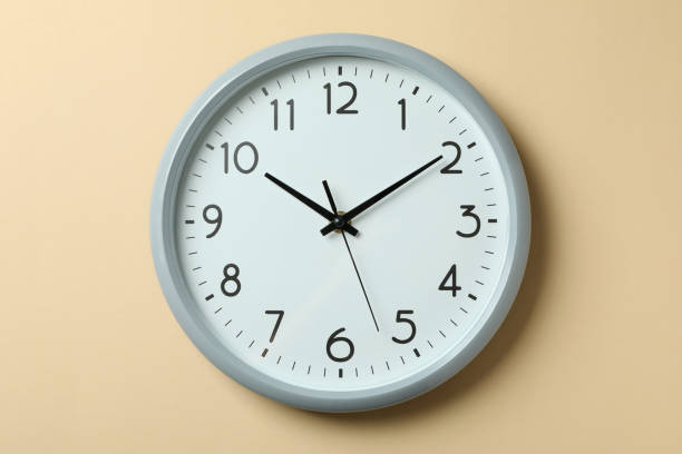 istock Standard gray home clock on beige background 1439960301