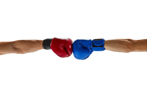 Two male hands in red and blue boxing gloves hit together isolated over white background. Copy space for ad, text. Sport, competition, challenges and combat sports