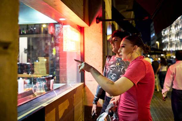 istock Young people looking through window and admiring food 1439962358