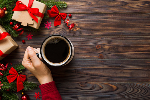 Woman holding cup of coffee. Woman hands holding a mug with hot coffee. Winter and Christmas time concept.