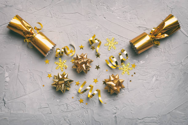 istock Christmas crackers with shiny confetti on color background, top view, copy space 1439963476