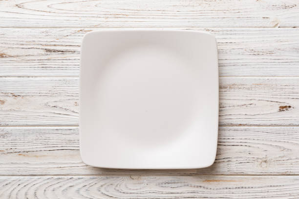 istock Top view of empty square plate on wooden background. Empty space for your design 1439965526