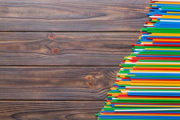 istock Heap of colorful plastic drinking straws on Colored background, flat lay. Copy Space for text 1439965541