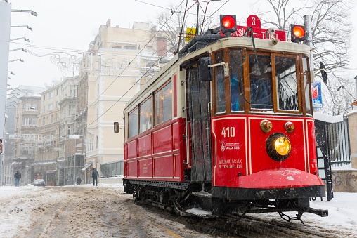 Istanbul, Turkey - January 7, 2017: Snowy day in Taksim, Beyoglu. Nostalgic tram in Istiklal Street. Taksim Istiklal Street is a popular destination in Istanbul, Turkey.