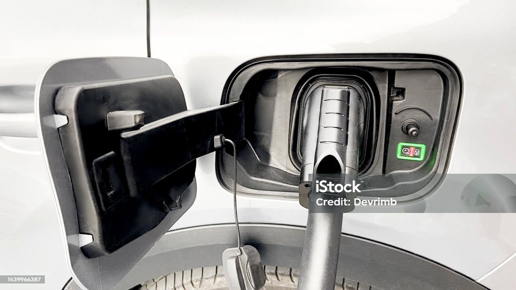 Electric Vehicle Charging Time At the charging station, the tank cover of the electric charging station of a white car is open and charging. / You can see the movie of this image from my iStock video portfolio. Video number: 1439137421 Alternative Fuel Vehicle Stock Photo