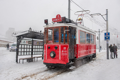 Istanbul, Turkey - January 7, 2017: Snowy day in Taksim, Beyoglu. Nostalgic tram in Istiklal Street. Taksim Istiklal Street is a popular destination in Istanbul, Turkey.